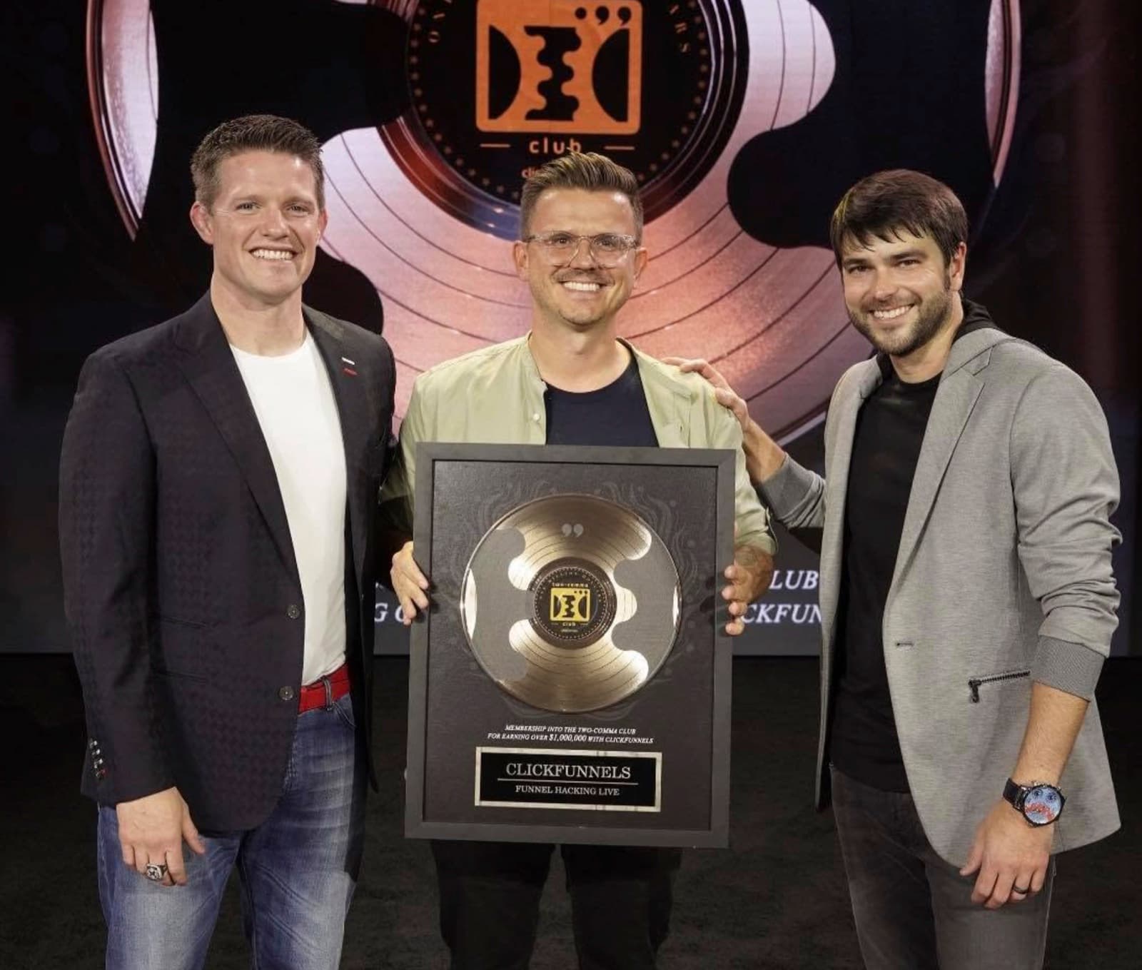 Marcin Teodoru holding his ClickFunnels Two Comma Club plaque